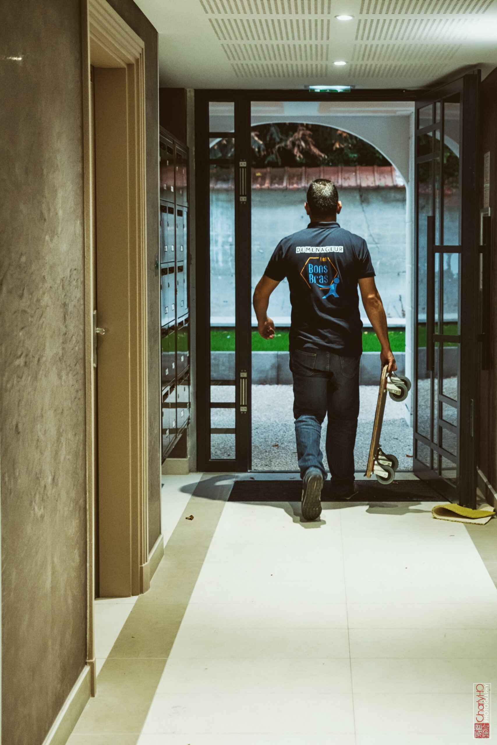 Déménageur qui sort d'un hall d'immeuble